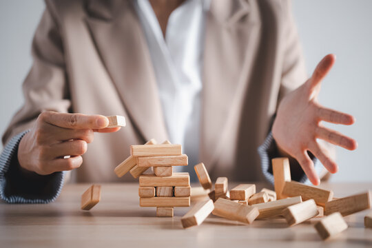 wooden block tower collapse with woman hand