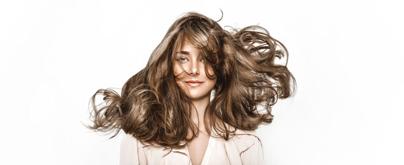 Portrait of a beautiful natural girl with beautiful healthy hair on a white background. A beautiful young girl with a perfect face and beautiful flowing hair. Beauty hair - concept.