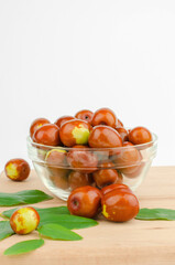 Bowl with fresh jojoba fruit on white background