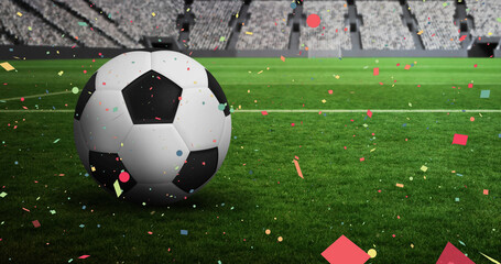 Colorful confetti falling against over close up of soccer ball in sports stadium