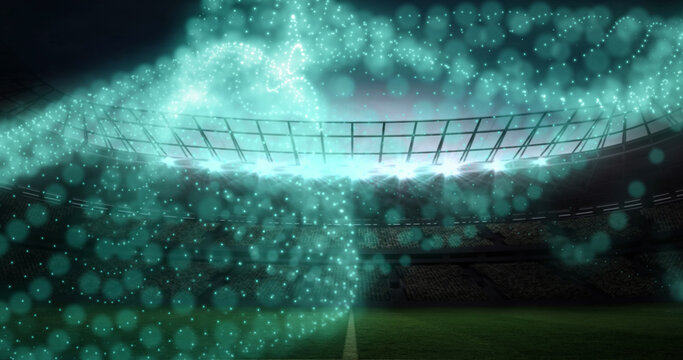 Image of network of glowing particles moving over floodlit sports stadium