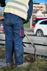 Worker with uniform maintaining street lawn.