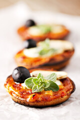 Mini Pizza Margherita with fresh Tomato, Mozzarella, Black Olives and Oregano.