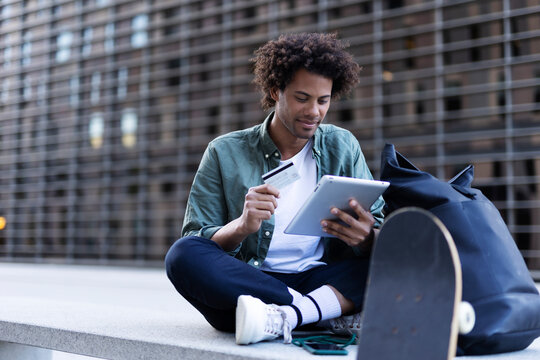Man buying online with a credit card and a digital tablet..