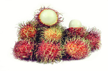 Several red and yellow rambutan balls piled together on a white background.