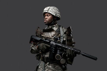 Shot of special forces soldier of african descent dressed in camouflage clothes holding rifle.