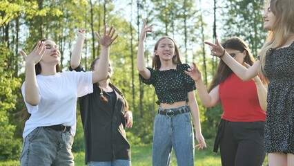 Joyful girls are dancing on a picnic near the forest.
