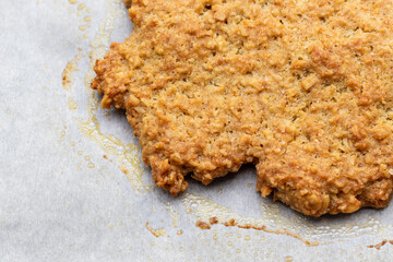 クッキングシートの上の焼きたてオートミールクッキー
