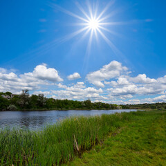 small calm river among green fields at summer sunny day, beautiful countryside landscape