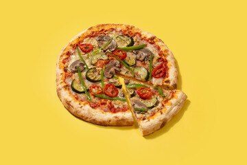 Vegetarian pizza with zucchini, tomato, peppers and mushrooms on yellow background