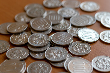 机の上に散らばる銀色の百円硬貨
