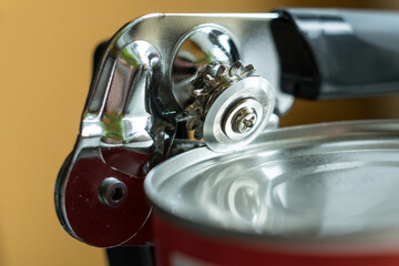 Tin opener opening a can in a kitchen.