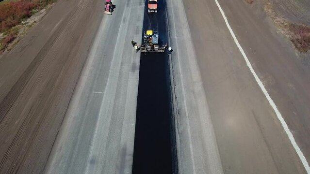 Drone view of the process of paving new asphalt. The process of laying new asphalt by asphalt pavers, drone view of road works