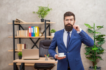 handsome bearded business man drinking coffee in the office with copy space, lunch break