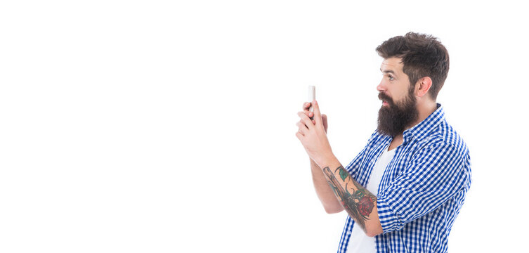 amazed brutal bearded man taking picture with phone isolated on white background with copy space