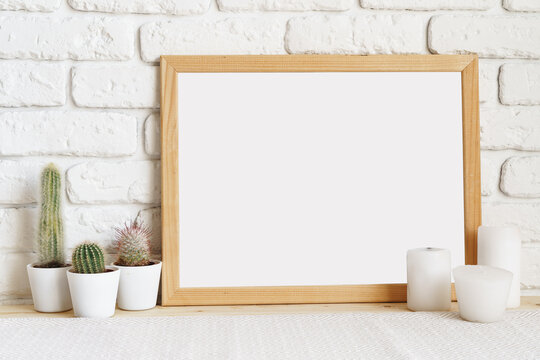 Square wooden photo frame and cactus plants on the table