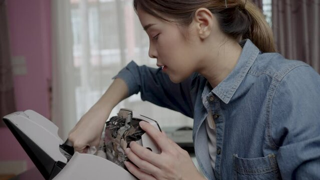 Beautiful Asian woman uses a microfiber cloth to clean the head of a document scanner.. Carriage, Optical Censer, Image Scanner.