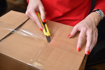 Hands opens the parcel with a clerical knife