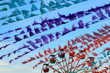 decoração junina com bandeirinhas coloridas em movimento e roda gigante 