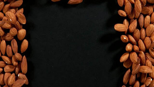 Super slow motion of blowing almonds on black background. Filmed on high speed cinema camera, 1000 fps.