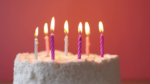 Burning candles are blown out on a cute girly birthday cake