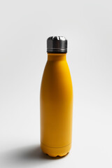 Close-up of reusable eco water bottle of yellow on white studio background.