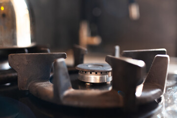 Close-up view of gas burner with cast iron grate. No fire.