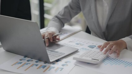 Closeup of hands are calculating on paperworks and laptop for bills, cost, accounting and budget for successful of new project.