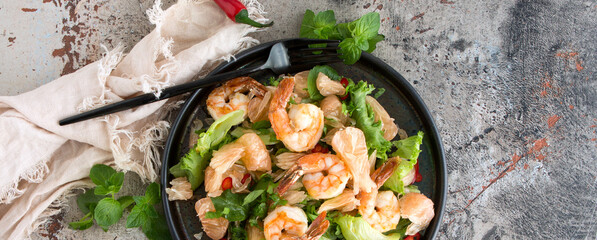plate with salad with pomelo and shrimps on the table