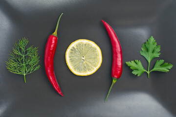 Fresh red hot peppers and lemon on a plate. Vitamin wholesome food.