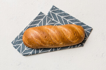 freshly baked bread with napkin on rustic table top view. Healthy white bread loaf isolated