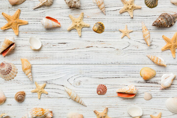 Summer time concept Flat lay composition with beautiful starfish and sea shells on colored table, top view with copy space for text