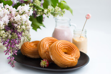 Cottage cheese rings on a platter beautifully decorated with a sprig of lilac. Milkshake with strawberries