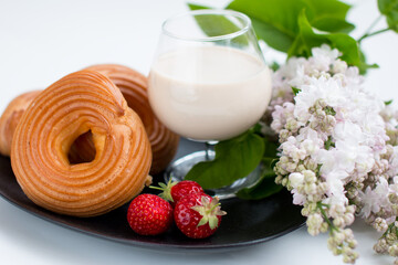 Cottage cheese rings on a platter beautifully decorated with a sprig of lilac. Milkshake with strawberries