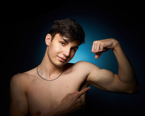 Fototapeta na wymiar a healthy athletic teenager shows off his body against a dark background, the concept of proper nutrition