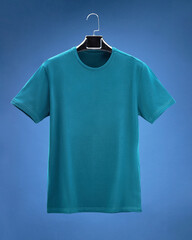 Dimensional T-shirt hanging on hanger, on dark blue background colours, navy, green, blue.