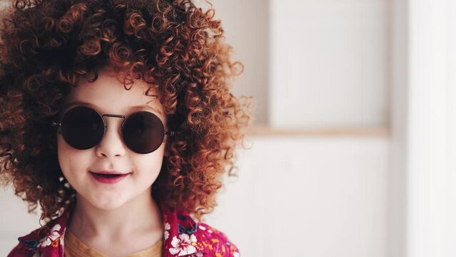 facial portrait of redhead curly kid in sunglasses