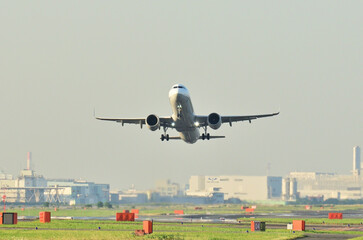 Fototapeta na wymiar ソラムナード羽田緑地から見る羽田空港を離陸するジェット機