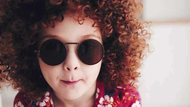 facial portrait of redhead curly kid in sunglasses
