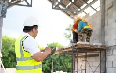 Engineers and architects supervise the construction of houses on residential construction sites.