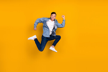 Fototapeta na wymiar Full size photo of young man jump run rush shopping carerfee wear casual clothes isolated over yellow color background