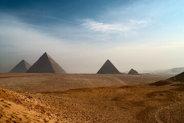 The great Egyptian pyramids. The deserted landscape with pyramids on Giza Plateau. - obrazy, fototapety, plakaty