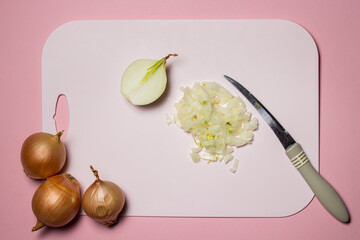 Finely chopped onion on a pink background. Cooking homemade food. Delicious and healthy vegetable