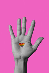 heart-shaped rainbow pride flag in a raised hand