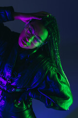 Stylish african american woman in smart glasses posing on dark blue background.