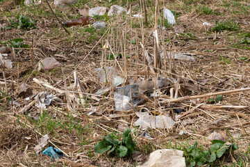 garbage bags and plastic bottles after the snow melts in spring. the concept of nature pollution by non-decomposing plastic