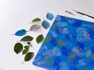 DIY Abstract botanical art. The picture is made by applying acrylic paints on the leaves and stamping on canvas.