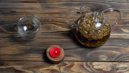 Top view of hot herbal tea in glass teapot on wooden background. Traditional herbal drink. Place for text or design.