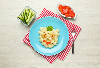 Tasty pasta served with vegetables on wooden table, flat lay. Creative idea for kid lunch