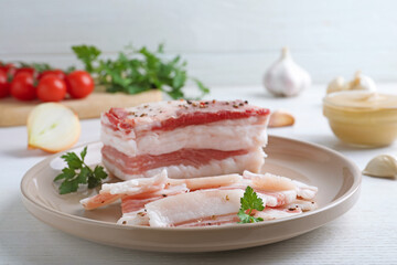 Tasty salt pork with parsley on white wooden table